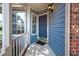 Close-up of a blue front door with sidelight windows and a 'welcome' mat on a covered porch at 6 Preakness Dr, Durham, NC 27713