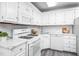 Bright kitchen features white cabinets, appliances, and granite countertops at 6 Preakness Dr, Durham, NC 27713