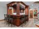 Basement wet bar with dark wood accents, barstool seating, and granite countertops at 6016 Glenthorne Dr, Raleigh, NC 27613