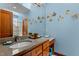 Bright bathroom with a granite countertop vanity, wood cabinetry, and unique fish decor at 6016 Glenthorne Dr, Raleigh, NC 27613