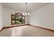 Formal dining room featuring hardwood floors, a large window, and a modern chandelier at 6016 Glenthorne Dr, Raleigh, NC 27613