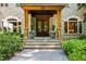 Close up view of the home's inviting entrance, including stone steps and lush plantings at 6016 Glenthorne Dr, Raleigh, NC 27613