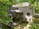 Rear exterior showcasing brick facade, multiple decks, a screened-in porch, and wooded surroundings at 6016 Glenthorne Dr, Raleigh, NC 27613