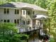 Rear exterior featuring light-gray brick, balconies, screened porch, and beautifully landscaped surroundings at 6016 Glenthorne Dr, Raleigh, NC 27613