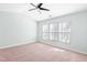 Comfortable bedroom with neutral walls, plush carpeting, a ceiling fan, and large window for ample natural light at 602 Walnut Woods Dr # 62, Morrisville, NC 27560