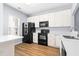 Bright kitchen featuring white cabinets, black appliances and durable wood-look flooring at 602 Walnut Woods Dr # 62, Morrisville, NC 27560