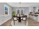 A dining area with modern table, chairs, and view of kitchen island, lit by natural light at 612 Miller Rd, Hillsborough, NC 27278