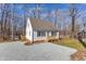Charming white home featuring a gravel driveway and a well-maintained yard with a natural wooded backdrop at 612 Miller Rd, Hillsborough, NC 27278