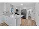 Modern kitchen with white cabinets, marble countertops, black appliances, and view into the bathroom at 612 Miller Rd, Hillsborough, NC 27278