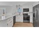 Bright kitchen features stainless steel appliances, white cabinetry, and wood flooring at 612 Miller Rd, Hillsborough, NC 27278