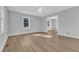 An empty living room with gray walls and hardwood floors, illuminated by natural light from the windows at 612 Miller Rd, Hillsborough, NC 27278