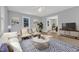 Staged living room with modern furniture and decor, featuring a blue rug and view into the dining area at 612 Miller Rd, Hillsborough, NC 27278