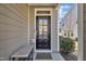 Stylish front door with glass inserts, complemented by a stone bench and manicured bushes at 640 Newlyn Dr, Raleigh, NC 27606