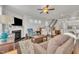 Inviting living room with a cozy fireplace, ceiling fan, and view of the staircase and modern kitchen at 640 Newlyn Dr, Raleigh, NC 27606