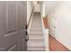 Inviting entryway featuring a staircase with carpeted steps and a wooden handrail in a brightly lit interior at 6734 Chauncey Dr, Raleigh, NC 27615