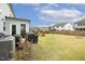 Spacious backyard with a lush green lawn, grilling area, wooden fence, and comfortable seating at 705 Marshall Farm St, Wake Forest, NC 27587