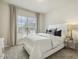 This bedroom features a comfortable queen bed with neutral bedding, a window with blinds, and gray carpet at 705 Marshall Farm St, Wake Forest, NC 27587