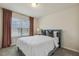 Bedroom showcases a comfy bed by the window with blinds, complemented by gray carpet and elegant brown curtains at 705 Marshall Farm St, Wake Forest, NC 27587