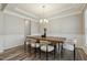 Elegant dining room featuring a modern chandelier, hardwood floors, and wainscoting at 705 Marshall Farm St, Wake Forest, NC 27587