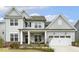 Charming two-story home with a well-manicured lawn, a covered porch and a two car garage at 705 Marshall Farm St, Wake Forest, NC 27587