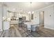 Bright open-concept kitchen with modern light fixtures, stainless steel appliances, and a large kitchen island at 705 Marshall Farm St, Wake Forest, NC 27587