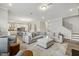 Open-concept living room with a large sectional sofa, hardwood floors, and modern decor at 705 Marshall Farm St, Wake Forest, NC 27587