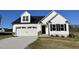 Charming white home featuring a two-car garage, black shutters, and a well-manicured lawn at 77 Heatherglenn Cir, Princeton, NC 27569