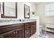 Bathroom with double vanities featuring granite countertops and dark wood cabinets at 81 N Lumina Ln, Clayton, NC 27527