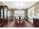 Formal dining room with a large window, hardwood floors, and elegant chandelier, perfect for Gathering gatherings at 81 N Lumina Ln, Clayton, NC 27527