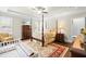 Relaxing main bedroom suite with tray ceiling, four-poster bed, and a cozy sitting area at 81 N Lumina Ln, Clayton, NC 27527