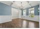 Open-concept living area with beautiful hardwood floors, white trim, and a modern chandelier at 834 November Ln, Willow Springs, NC 27592