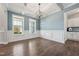 Inviting living area showcasing wood floors, large windows, a contemporary chandelier, and white trim at 834 November Ln, Willow Springs, NC 27592