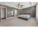 This main bedroom has a carpeted floor, a bed, a ceiling fan, and an entrance into the main bathroom at 834 November Ln, Willow Springs, NC 27592