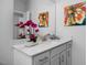 Modern bathroom with a white quartz countertop, a decorative flower arrangement, and a large mirror at 88 Baldwin St, Lillington, NC 27546