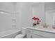 Bright bathroom featuring a shower/tub combo, vanity, and decorative flowers at 88 Baldwin St, Lillington, NC 27546