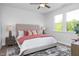 Bright bedroom featuring a ceiling fan, hardwood floors, and large windows at 88 Baldwin St, Lillington, NC 27546
