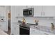 Well-equipped kitchen featuring stainless steel appliances, granite countertops, and white cabinets at 88 Baldwin St, Lillington, NC 27546