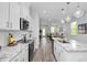 Open kitchen with an island, stainless appliances, granite counters, and views into the living area at 88 Baldwin St, Lillington, NC 27546