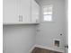 Clean laundry room with white cabinets, a window for natural light, and utility connections at 88 Baldwin St, Lillington, NC 27546