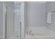 A bright bathroom featuring a glass-door shower and a relaxing soaking tub at 1000 Milkweed Ct, Zebulon, NC 27597
