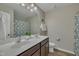 Bathroom featuring double sinks, a large mirror, and decorative floral shower curtain at 1000 Milkweed Ct, Zebulon, NC 27597