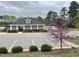 Community clubhouse with parking lot and landscaped grounds, including a flowering tree at 1000 Milkweed Ct, Zebulon, NC 27597