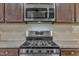 Close-up of a kitchen featuring stainless steel appliances and dark wood cabinets at 1000 Milkweed Ct, Zebulon, NC 27597