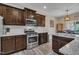 A modern kitchen featuring stainless steel appliances, granite countertops, and dark wood cabinetry at 1000 Milkweed Ct, Zebulon, NC 27597