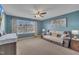 Relaxing living room with blue walls, a brown leather sofa, and a ceiling fan at 1000 Milkweed Ct, Zebulon, NC 27597