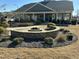 Beautiful outdoor area with a stone fire pit surrounded by meticulously maintained landscaping at 103 Thornwhistle Pl, Garner, NC 27529