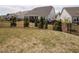 Well-maintained backyard featuring a black metal fence and manicured trees, creating a private and secure outdoor space at 107 Canary Ct, Raleigh, NC 27610