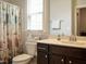 Charming bathroom with coastal-themed shower curtain, dark wood vanity, and natural light at 107 Canary Ct, Raleigh, NC 27610