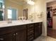 Double vanity bathroom featuring a dark wood cabinet, white countertop and a spacious walk-in closet at 107 Canary Ct, Raleigh, NC 27610