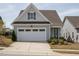 Charming home featuring a spacious garage, a classic gable roof, and well-manicured landscaping, creating a welcoming curb appeal at 107 Canary Ct, Raleigh, NC 27610
